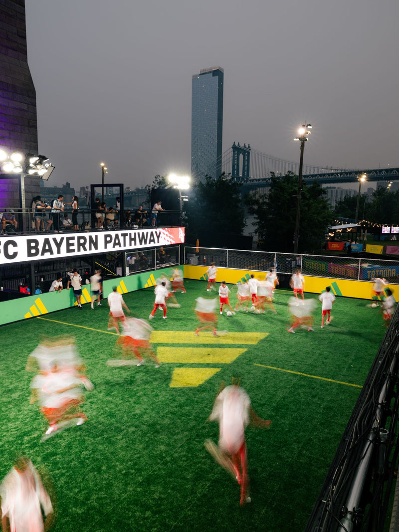 Blurred small-sided game on a rooftop pitch at dusk