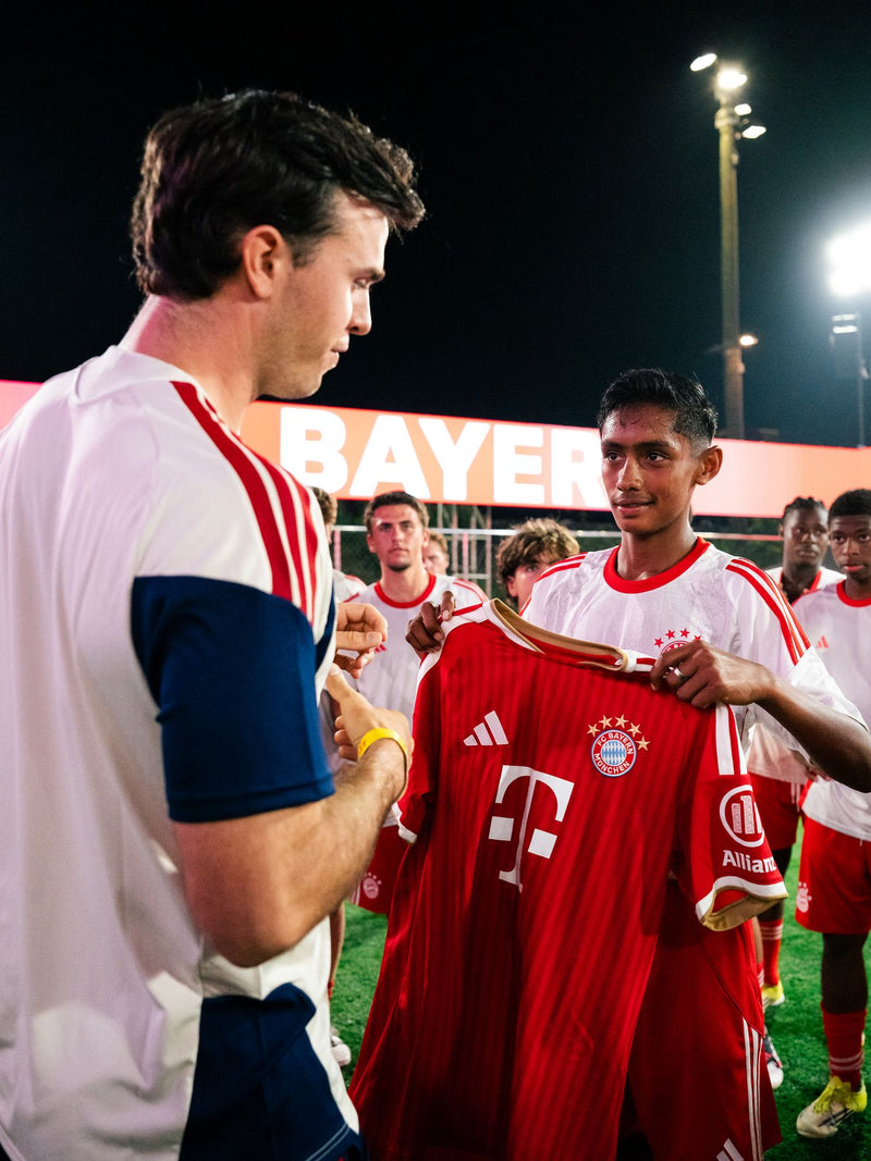 Player handing a shirt to a young participant