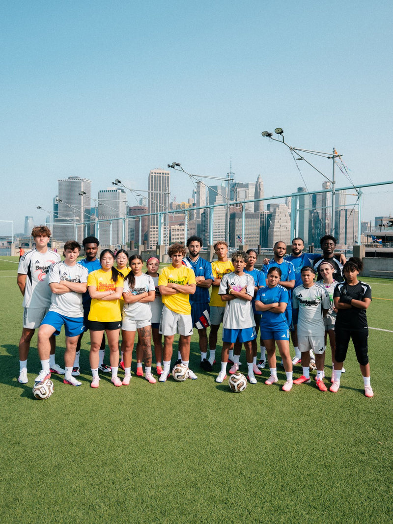 Group photo of participants on a pitch with the skyline behind