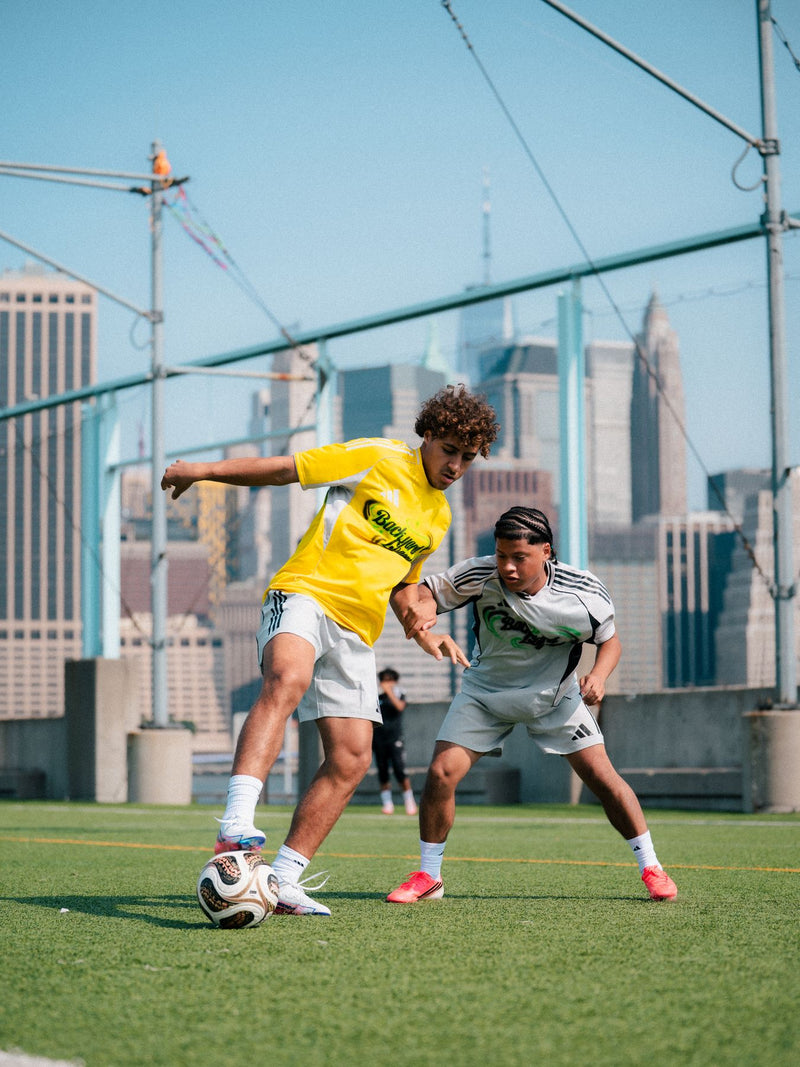 One-on-one duel on a pitch with the city skyline behind