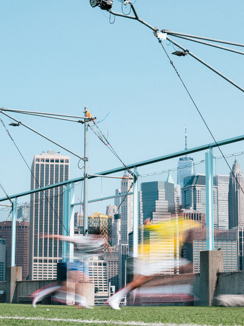Blurred players on a pitch framed by the skyline