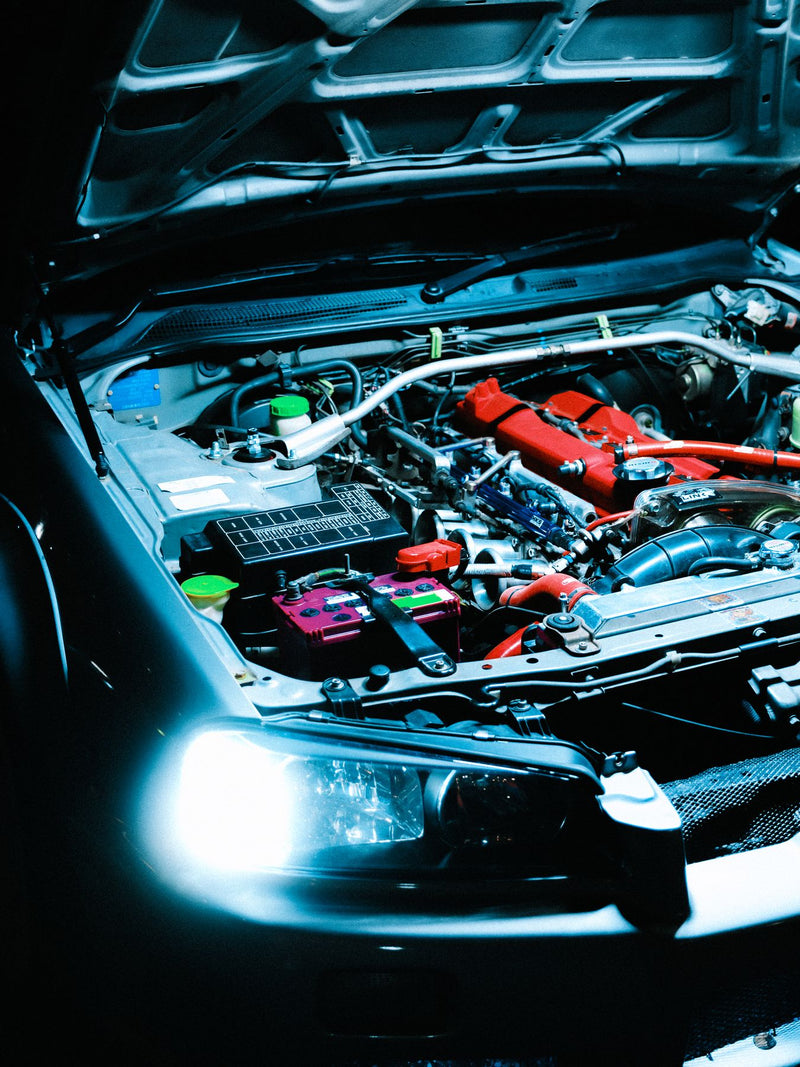 Modified engine bay with the bonnet raised, headlights on