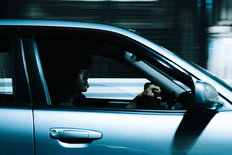 Driver seen through the window of a saloon car at night