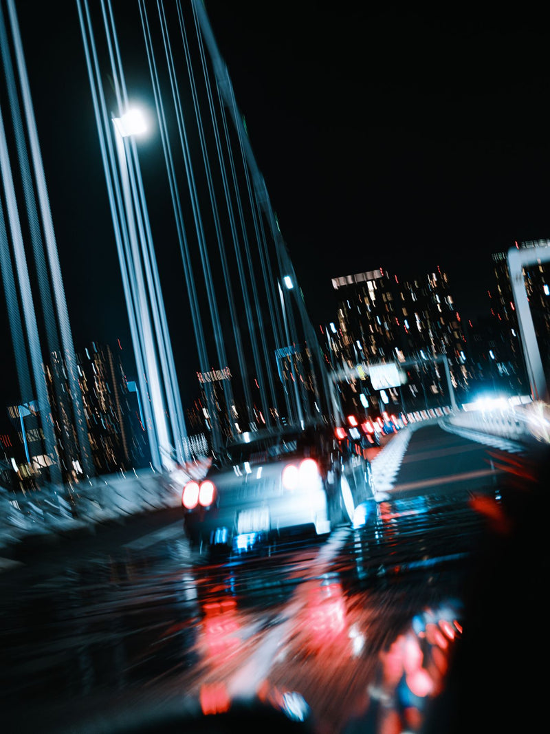 Blurred night drive between city towers
