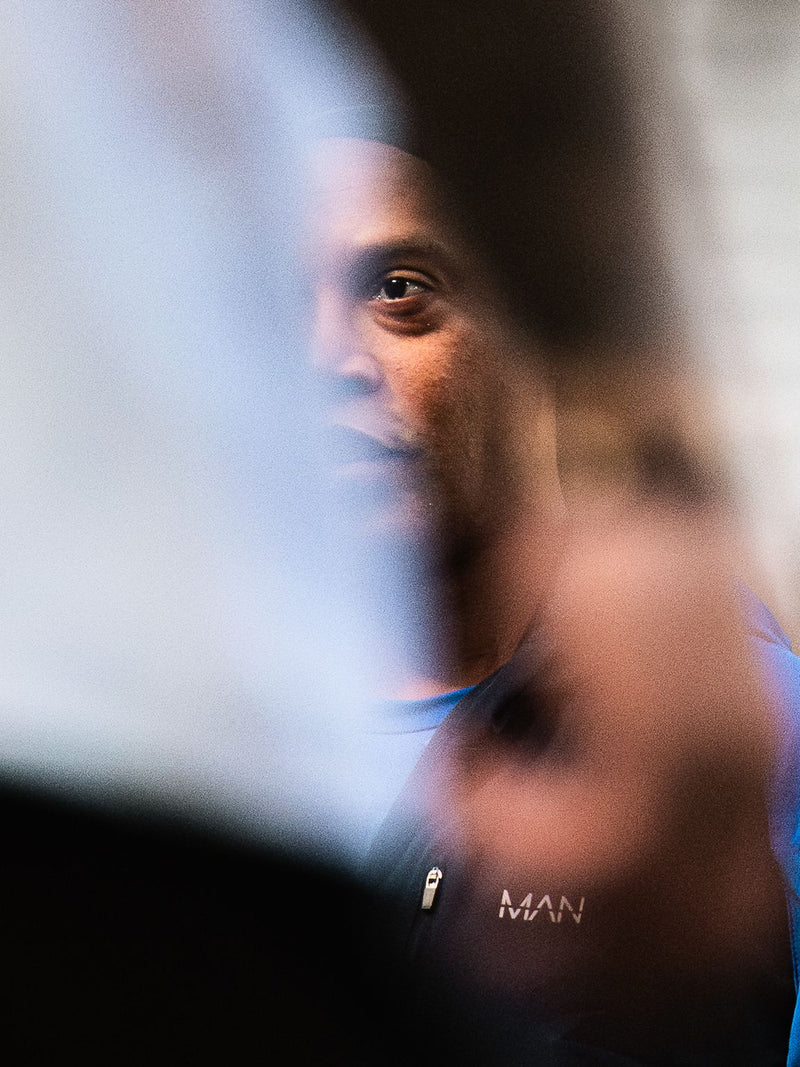 Close portrait of a footballer seen past an out-of-focus flag