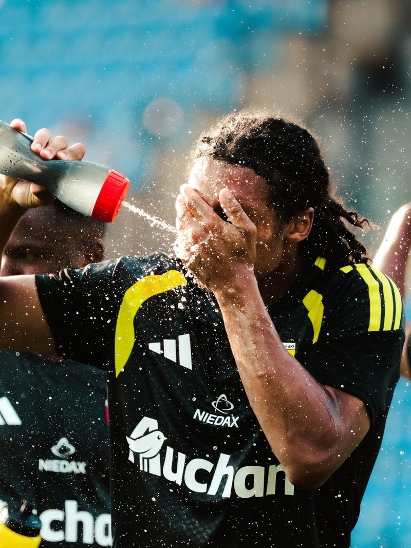 Player spraying water over his face on the touchline