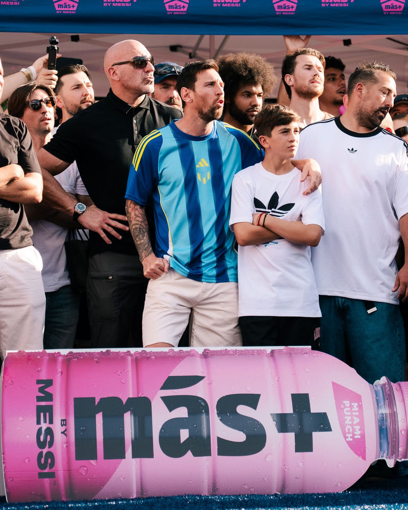 Footballer walking past supporters behind a branded barrier