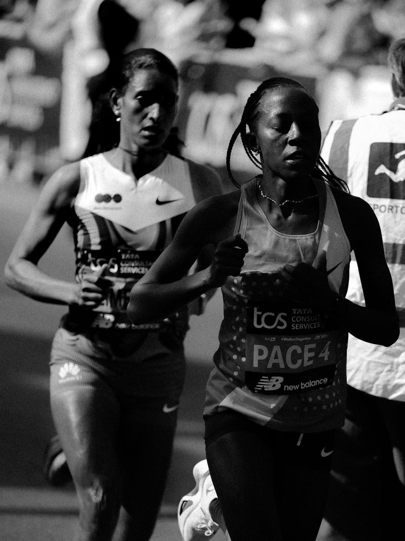 Black and white frame of elite women running in a marathon pack