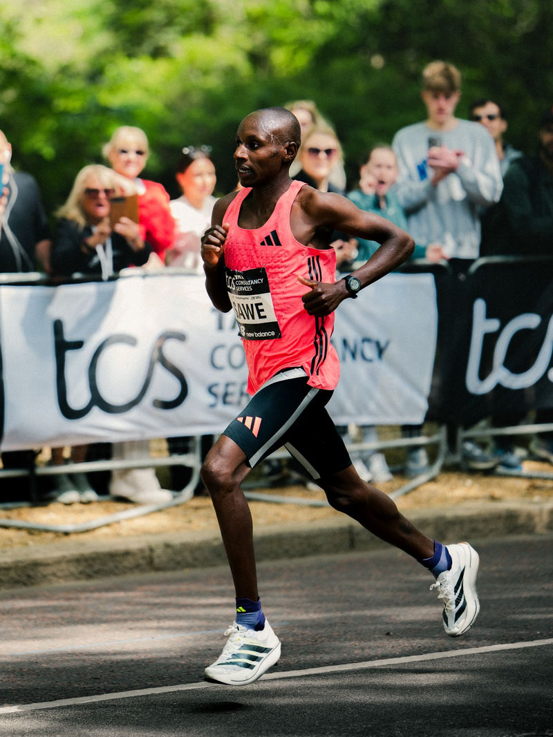 Runner in a pink singlet passing the crowd barriers