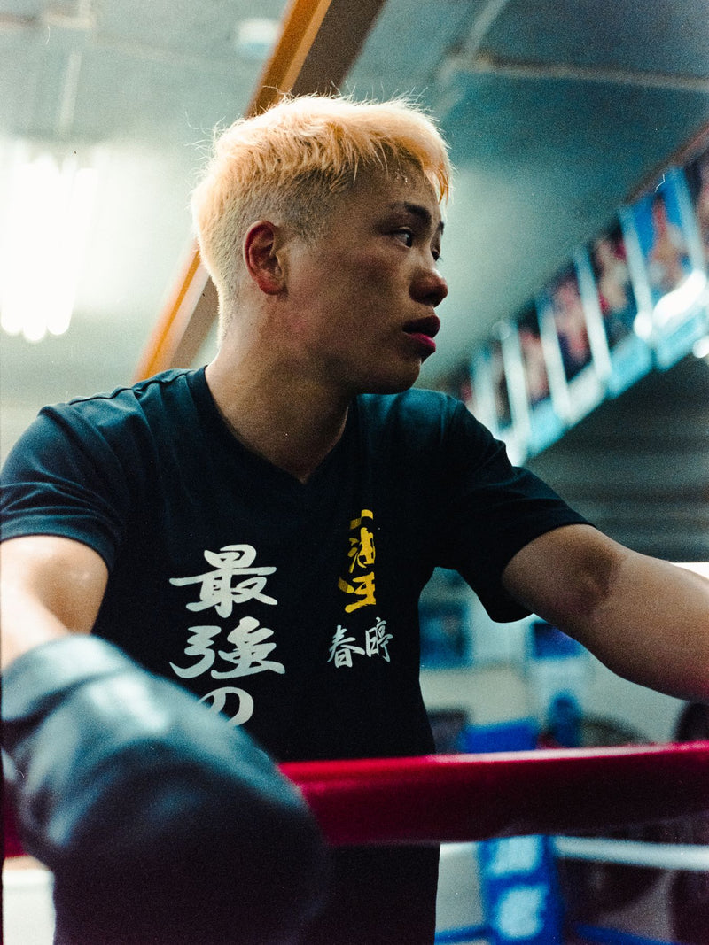 Boxer with bleached hair resting on the ropes